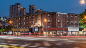 Un edificio de varios pisos con un letrero que dice 'Panda Hotel' en la fachada.