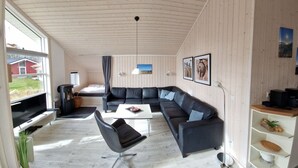A modern living room with a sectional sofa, a coffee table, and a TV. - Skandinavisches Haus fur 10 (Grossenbrode)