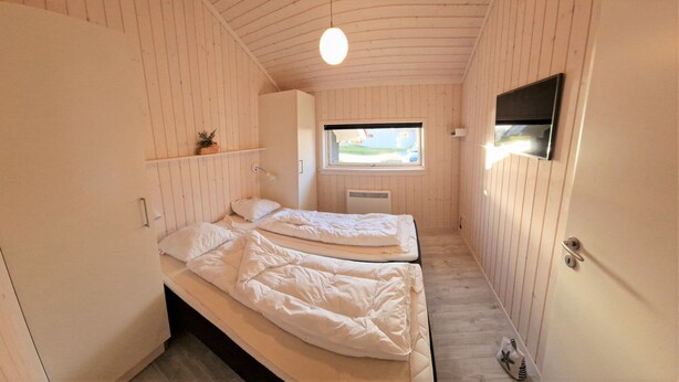 A compact bedroom with two beds, a window, and a TV. - Skandinavisches Haus fur 10 (Grossenbrode)