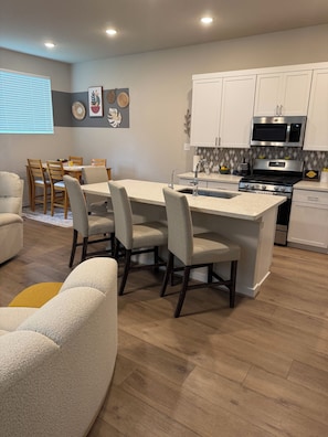 A modern kitchen with white cabinets, a stainless steel microwave, and a gas stove. - Fully Furnished 3-bedroom house in San Antonio with cool AC (San Antonio)