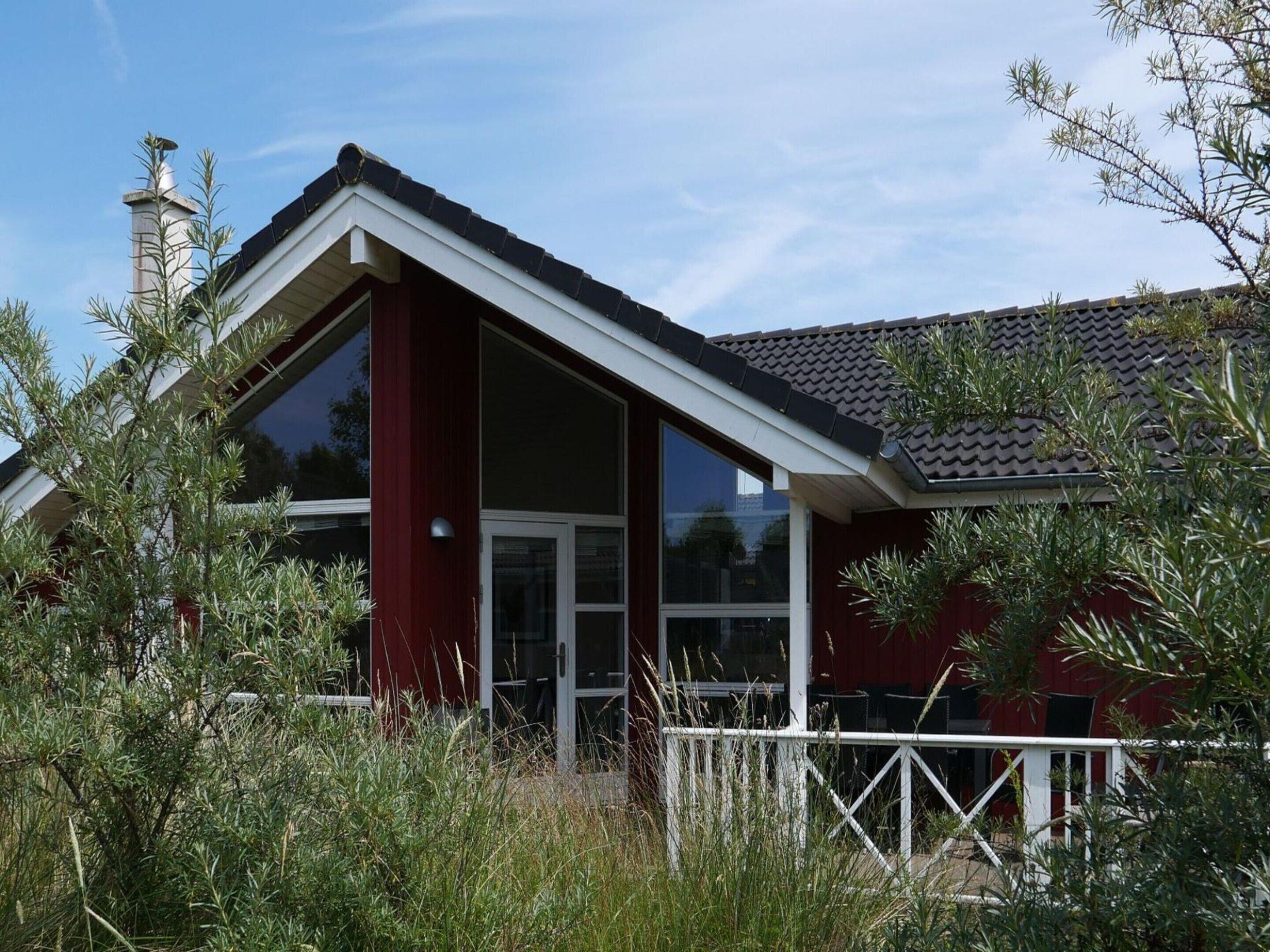 A red building with a white roof and a large glass window.