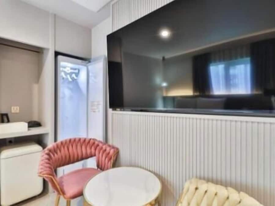 Habitación de hotel con cama, una mesita redonda, una silla, televisor y ventana.