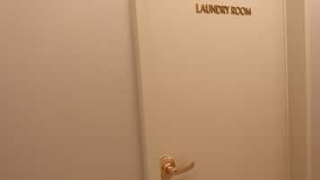 A door with a gold handle and the words 'LAUNDRY ROOM' on the door frame.
