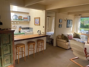 A cozy living area with a sofa, a coffee table, and a view of the outdoors. - COSY PORTSEA COTTAGE (Melbourne)