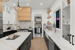 A modern kitchen with a central island, built-in appliances, and a variety of storage options. - Large Luxury New Modern home w/ Patio/AC/Bar (Delta)