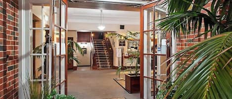 A brick building entrance with a staircase leading to an upper level.