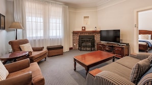 Una sala de estar con chimenea, televisor y zona de estar.