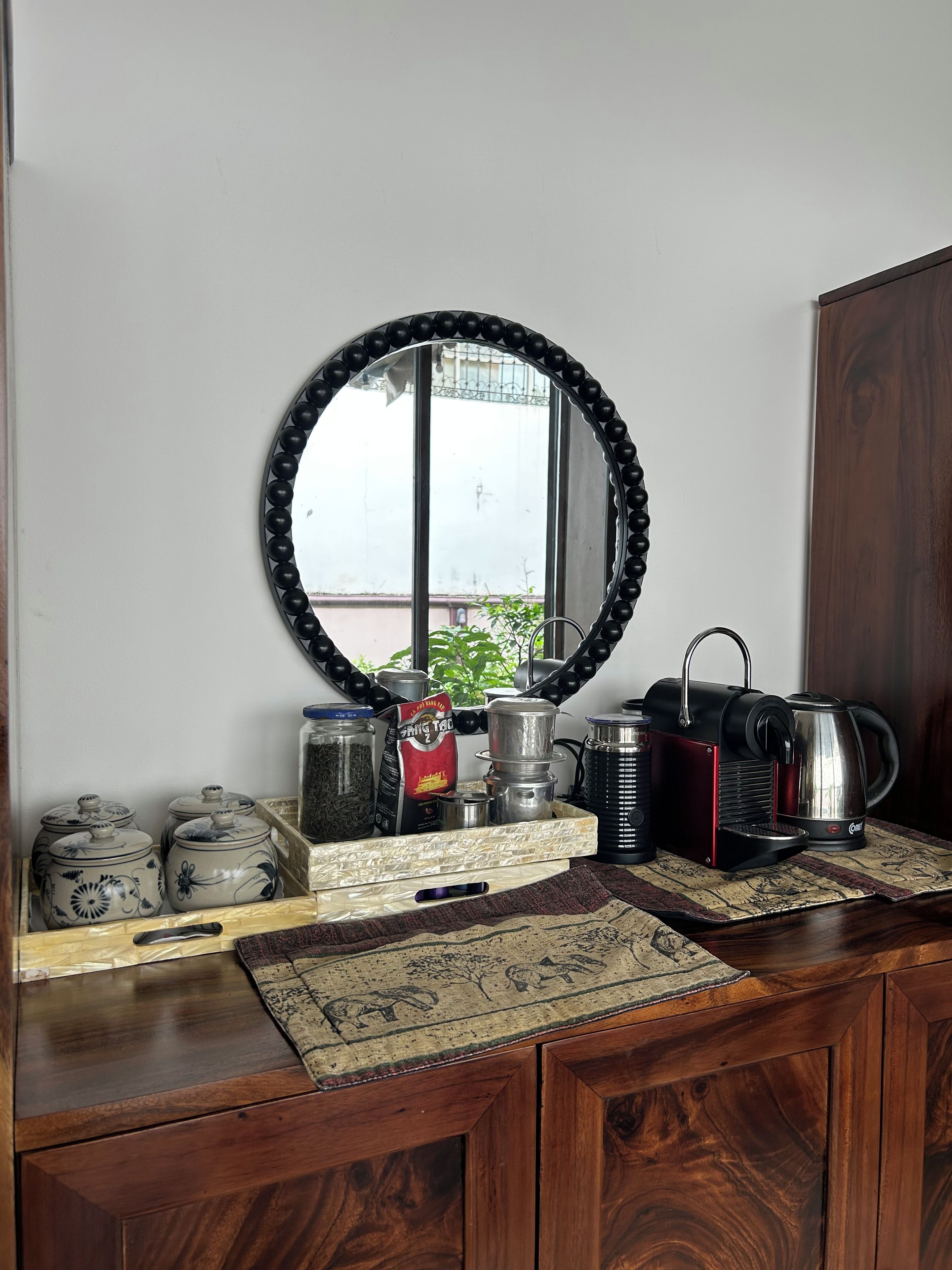 Uma bancada de cozinha com cafeteira, chaleira e potes de armazenamento.