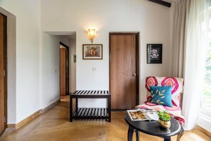 A hallway with a wooden bench, a door, and a wall-mounted light fixture.