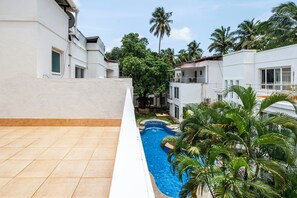 Ein Wohngebiet mit Swimmingpool, weißen Gebäuden und Palmen.