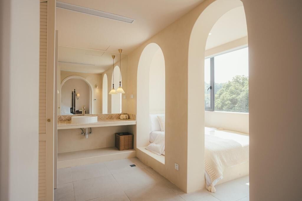 A modern bathroom with a large window, a built-in bench, and a vanity with a mirror.