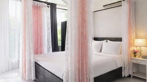 Une chambre d’hôtel avec un lit, des rideaux, une table de chevet avec une lampe et une vue sur la verdure.