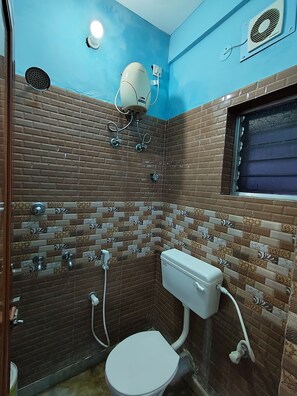 A bathroom with a toilet, a shower, and a window. - Singh Guest House (Alipur)