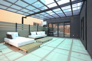 A modern interior with a glass ceiling, a sofa, a bed, and a small table. - b&Kuromon 4 (Osaka)
