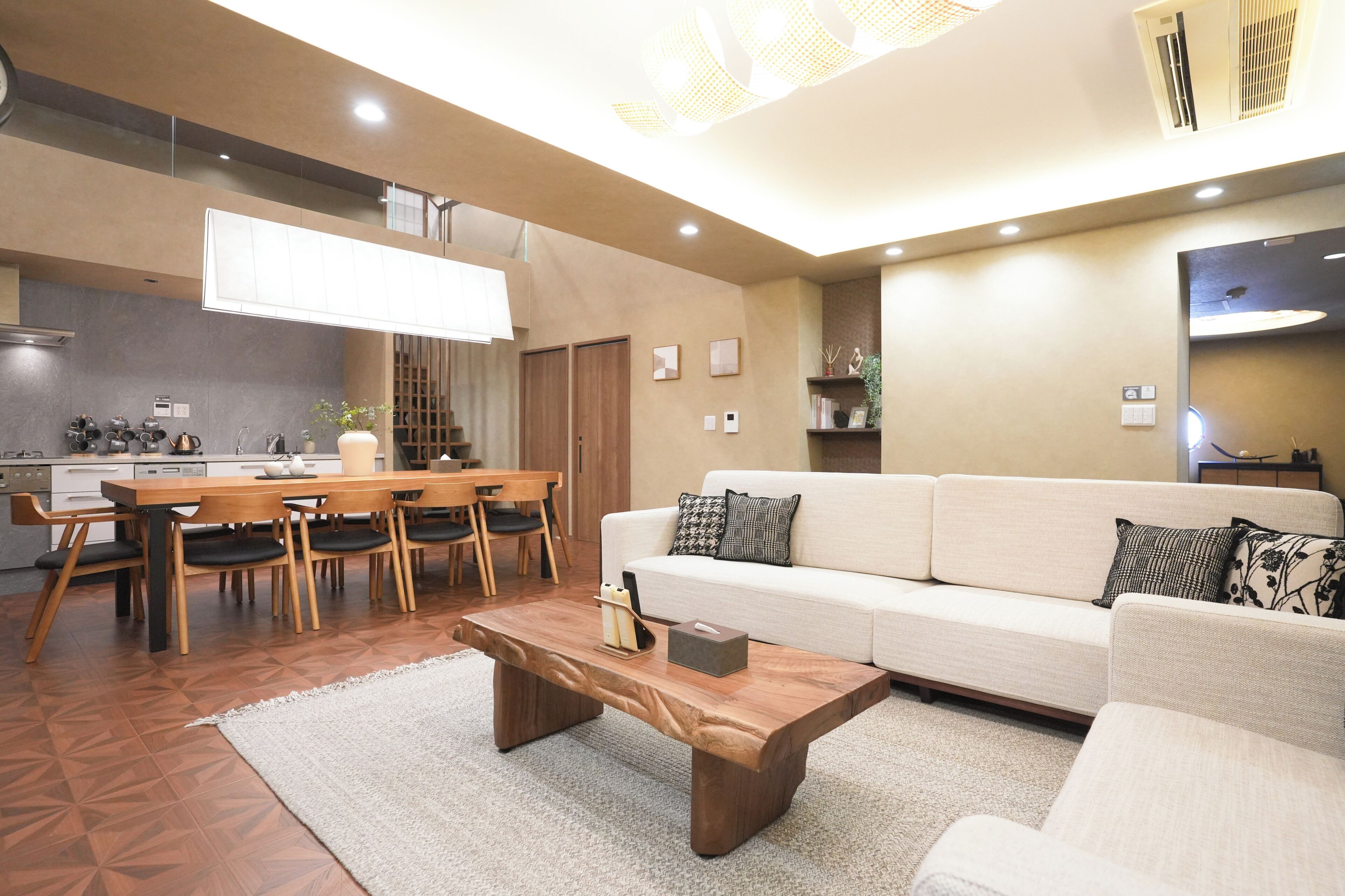 A modern living room with a sofa, coffee table, and dining area with chairs.