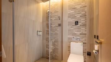 A modern bathroom with a glass shower enclosure, a toilet, and a sink.