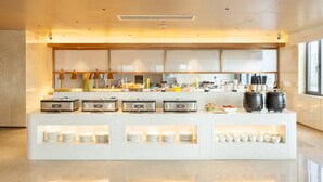 A modern breakfast bar with a clean design, equipped with various appliances and a selection of dishes. - Meilifeng Hotel  (Weihai)