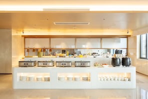 Una barra de desayuno moderna con un diseño limpio, equipada con diversos electrodomésticos y una selección de vajilla.