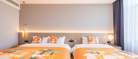 A hotel room with two beds, each with orange bedding featuring animal prints, a bedside table with a lamp, and a large window with curtains.