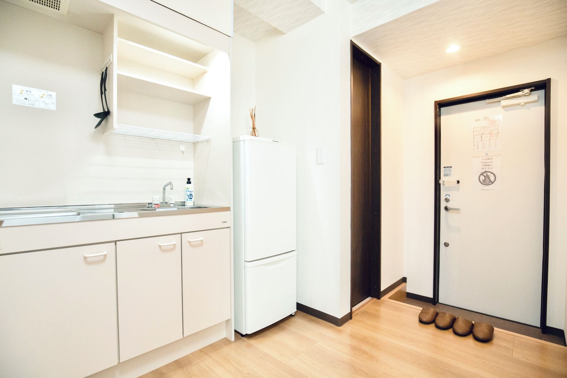 A modern kitchen with a refrigerator, sink, and cabinets.