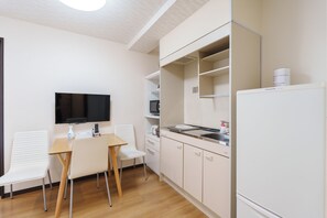 A compact kitchenette with a microwave, a sink, and a refrigerator. There is a small dining area with a table and two chairs. - SERENE Osaka | 3 Minutes from Kuromon | 6F-603 | 35 ㎡, 2-Bedroom | Sleeps 4 (Osaka)