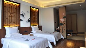 Habitación de hotel con dos camas, cabecero de madera, pared con un panel decorativo y vista a un pasillo.