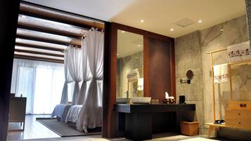 Un baño moderno con un espejo grande, un lavabo y una zona de ducha.