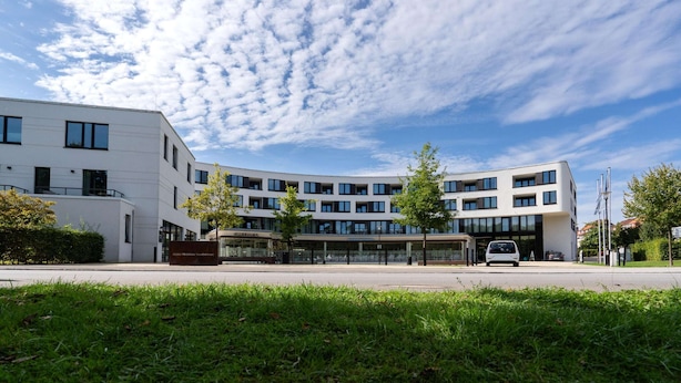 Un bâtiment moderne à plusieurs étages, doté de grandes fenêtres et d’un toit plat.