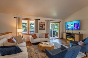Ein Wohnzimmer mit einer Sofagarnitur, einem Couchtisch und einem Fernseher, der eine Streaming-Dienstanwendung anzeigt.