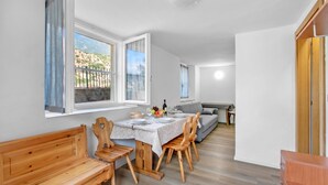 A compact living space with a dining area, a sofa, and a wooden bench. - Falesia Vertical Rock View (Arco)