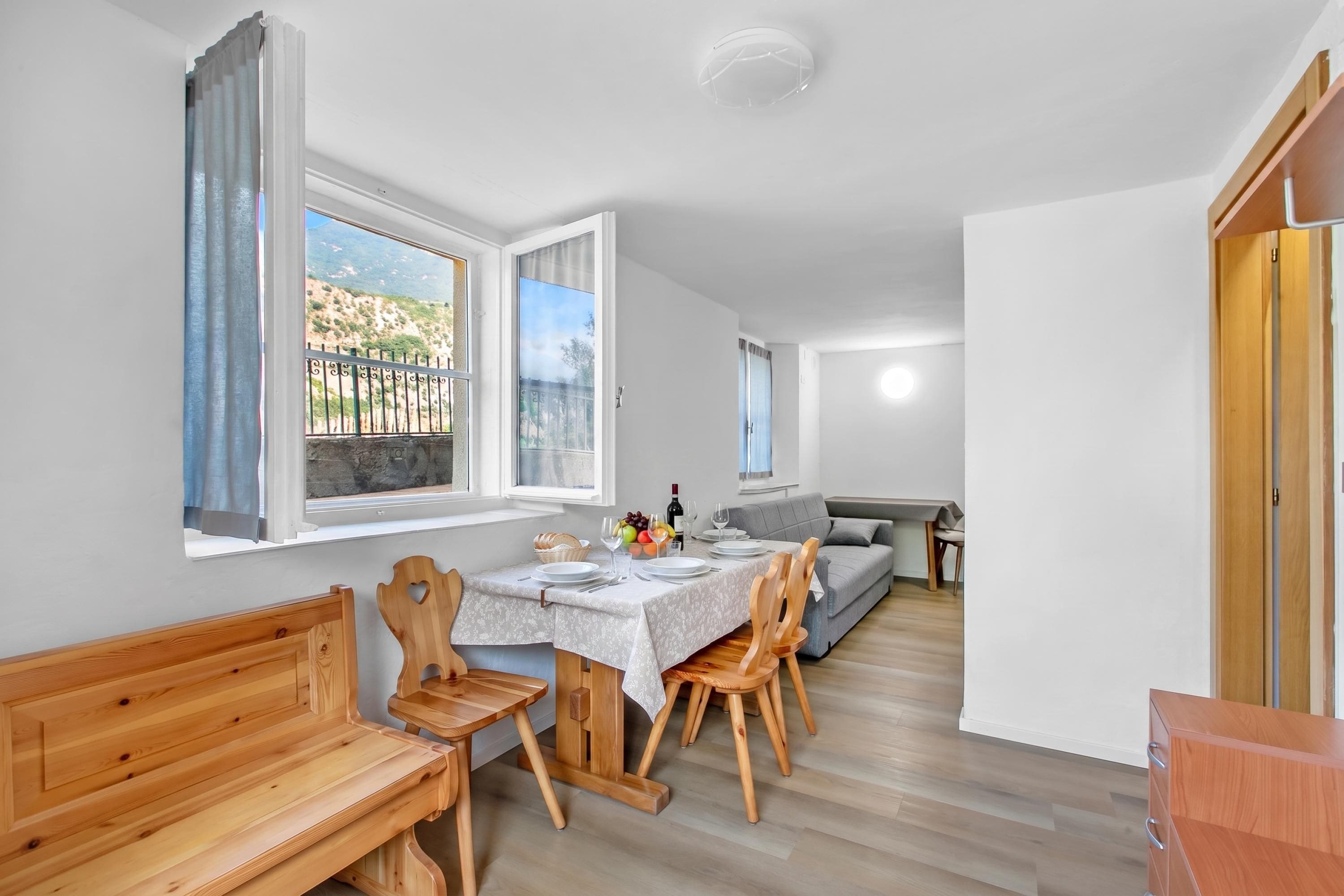 A compact living space with a dining area, a sofa, and a wooden bench.