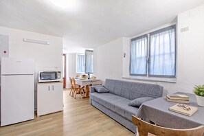 A compact living space with a kitchenette, a dining area, and a sofa. - Falesia Vertical Rock View (Arco)
