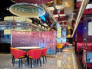 A modern interior with a central seating area, a patterned floor, and a ceiling with circular light fixtures.