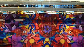 A room with a patterned floor, a red cabinet, and a colorful mural with floral and fish designs.