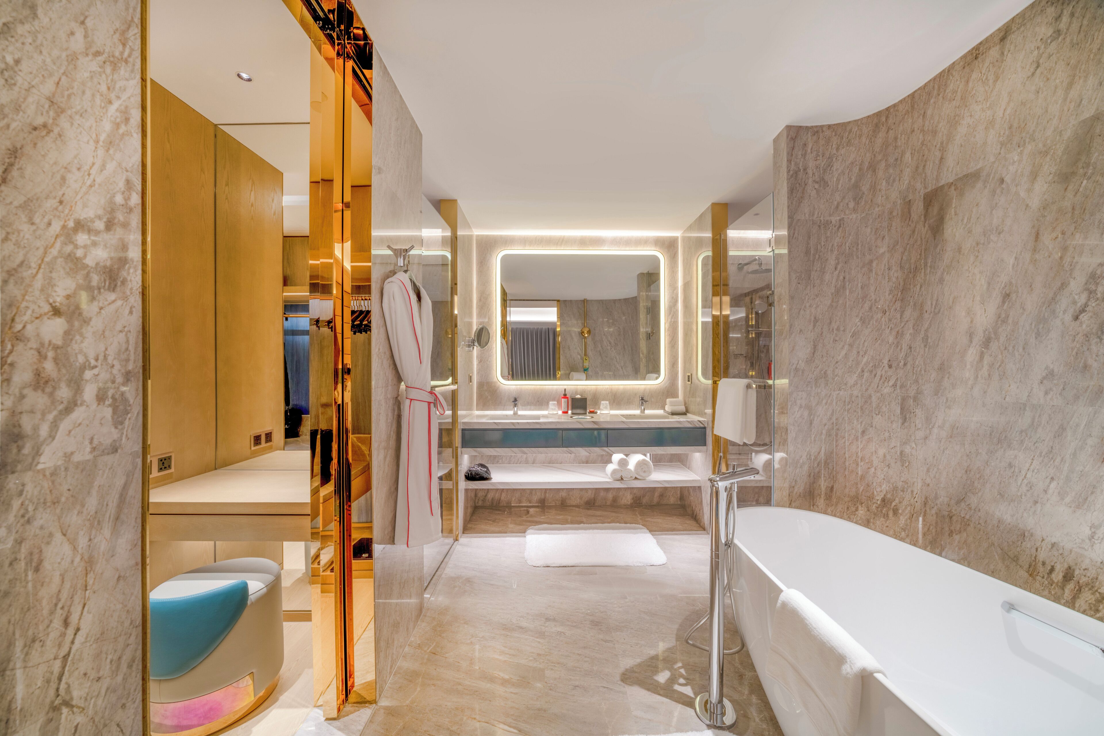 Un baño moderno con bañera, tocador con espejo y bata colgada en un perchero.