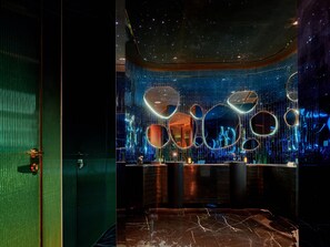 Un interior moderno con una pared reflectante, una recepción y un piso de mármol.