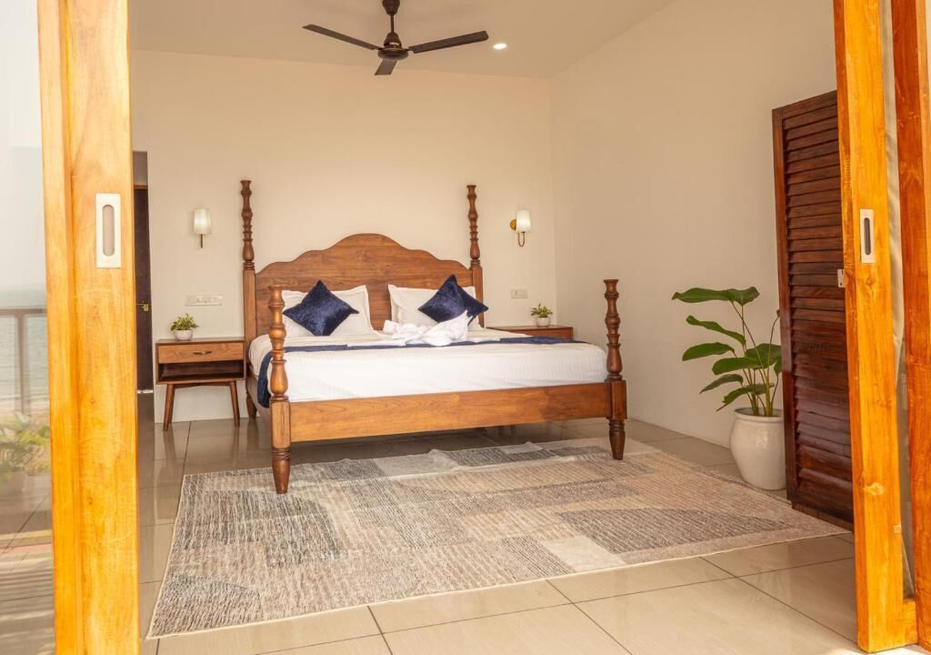 Un dormitorio con cama de madera, mesitas de noche, ventilador de techo y una planta en maceta.