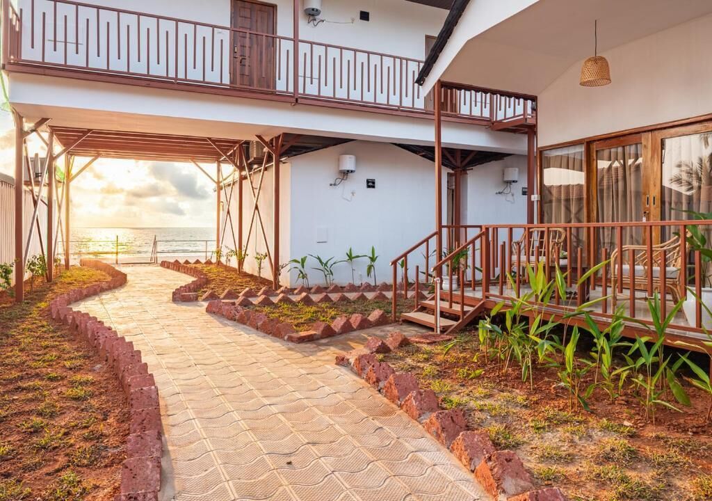 A two-story building with a covered outdoor area, a staircase, and a view of the sea.