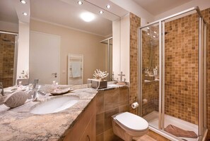 Ein Badezimmer mit Waschbecken, Toilette und einer Duschkabine.