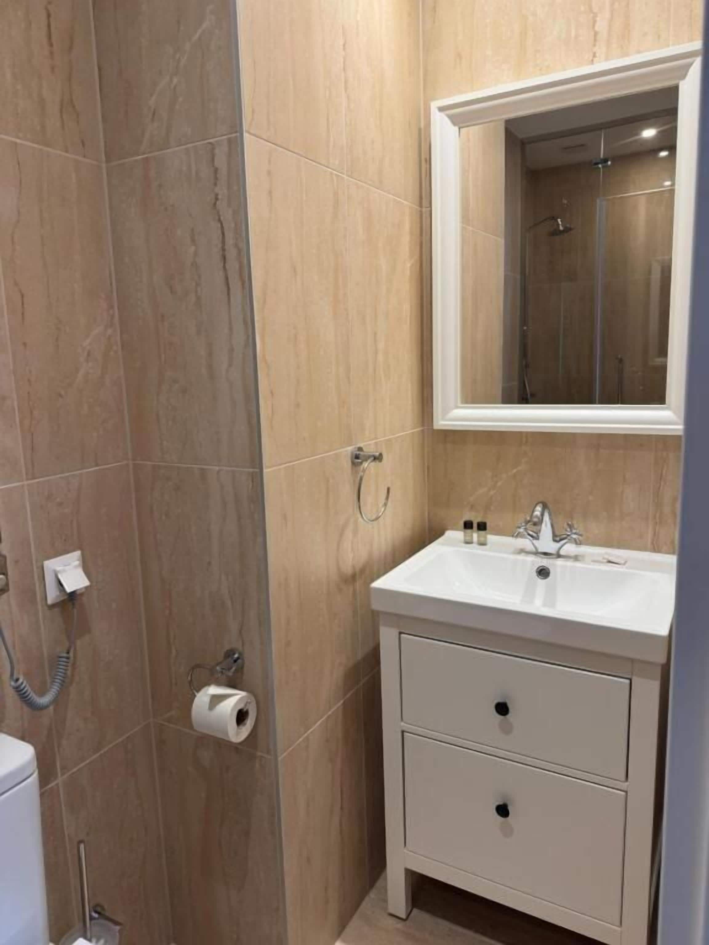 Ein Badezimmer mit Dusche, Toilette und Waschbecken.