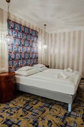 Um quarto com uma cama grande, papel de parede listrado e um tapete estampado.