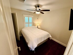 A bedroom with a bed, a ceiling fan, a window with blinds, and a nightstand with a lamp. - 30+Day Extended Stay: 3bd 2.5 bath corporate stay (San Antonio)