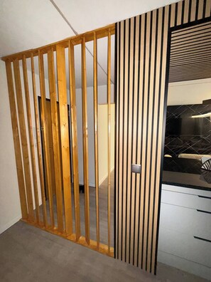 A room with a wooden partition, a black countertop, and a white wall. - Luxury 3BR Apartment 2 Baths Near Lisbon & Sintra (Sintra)