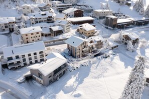 A snow-covered residential area with various buildings, including houses and a hotel. - Lenzerheide Luxury: Spa Shower, Mountain View (Lenzerheide/Lai)