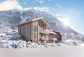 A modern wooden building with large windows, a balcony, and a mountainous backdrop. - Lenzerheide Luxury: Spa Shower, Mountain View (Lenzerheide/Lai)