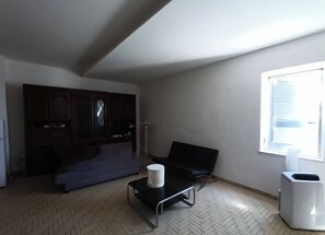 A living room with a sofa, a coffee table, a cabinet, and a window. - !editerranean beach dream directly on the sea ! (Castel Volturno)