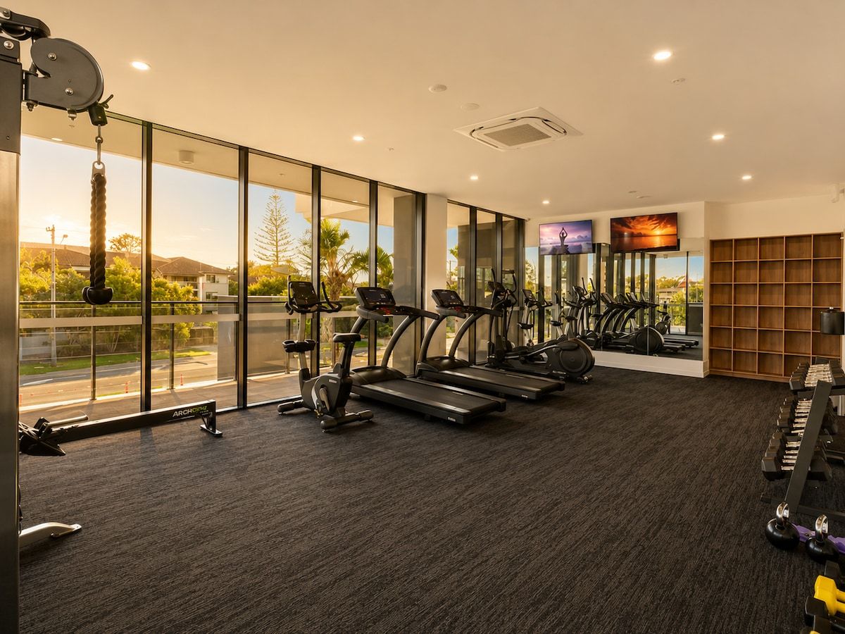 A gym with treadmills, stationary bikes, and weight machines.