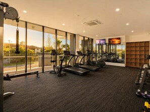 A gym with treadmills, stationary bikes, and weight machines. - Burleigh Beach Views | 2BR, Pool, Gym & Parking (Burleigh Heads)