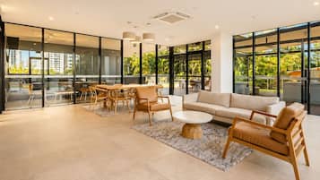 A modern living room with a sofa, chairs, and a dining table.