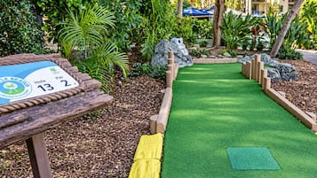 A miniature golf course with a wooden sign indicating hole 13 and par 2.